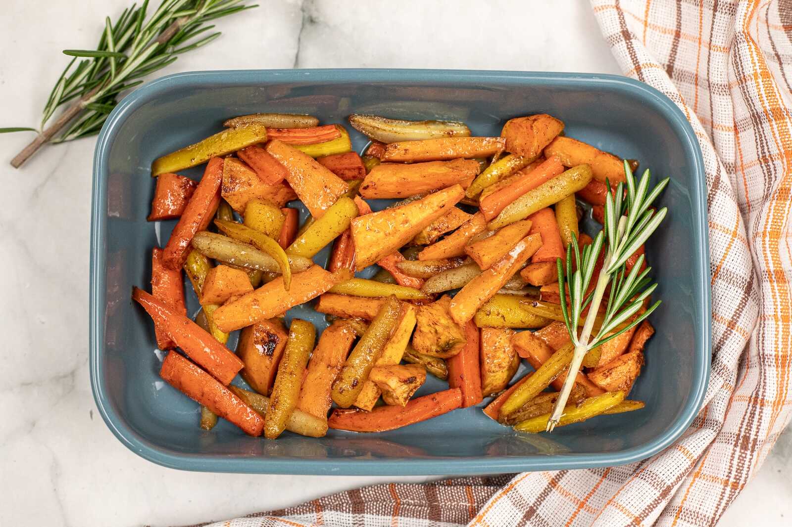 Oven roasted vegetables served in a baking dish with carrots, parsnips, and squash.