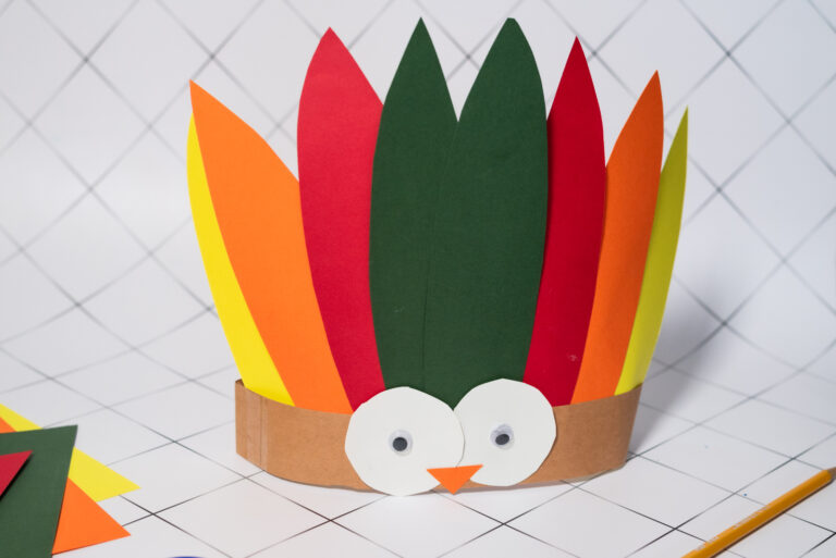 Colorful Turkey Headband Craft for kids with paper feathers and googly eyes.
